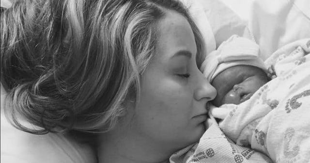 A sleeping woman with her newborn child on her chest in black and white