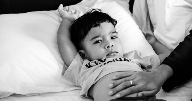 Little boy in bed while his mom is touching his belly