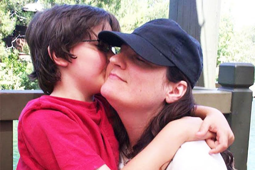 Ilisa Aaron Parish in a black cap being hugged by her son in a red T-shirt