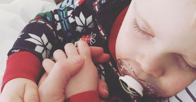 Lindsey M. Henke's kid sleeping in her arms while being sick