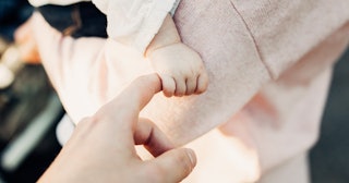 Baby holding adult's finger