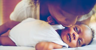 A mother kissing her black son's cheek