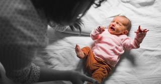 A mother approaching a newborn baby that has contracted a virus and became critically ill during a '...