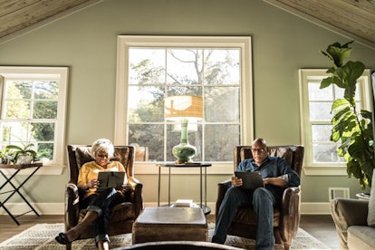 Grandparents sitting in their living room with their tablets