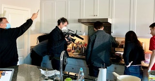 Gary Sinise with a group of people in a kitchen during a charity event