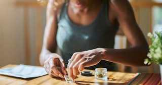 A good mom who loves cannabis sitting at a dining table and preparing cannabis to use it
