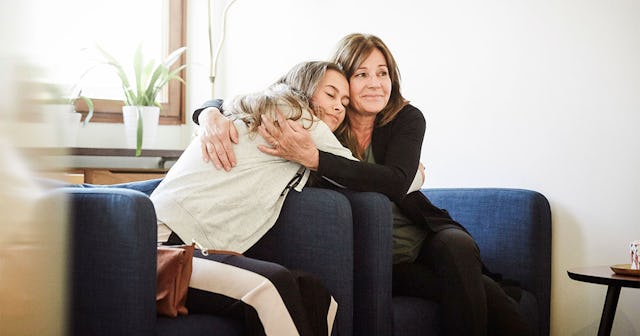 A mother hugging her teen daughter.