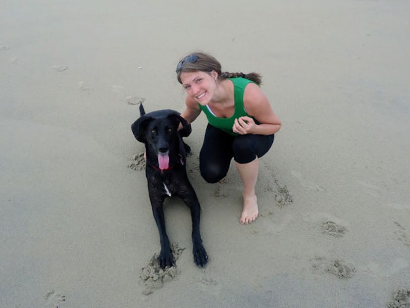 Stacy Seltzer with her dog, smiling, at a beach.