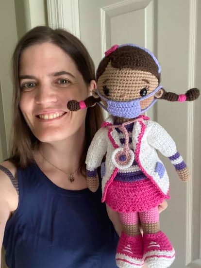 Dr. W, holding her knitted-out doll, a cute girl with pigtails, a medical mask and pink matching out...