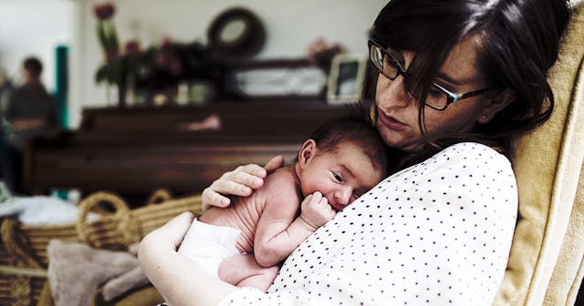  A mother with her newborn on her chest experiencing the mental load of new motherhood
