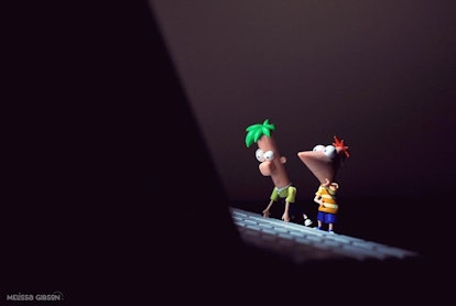 Fineas and Ferb toys placed on a laptop's keyboard