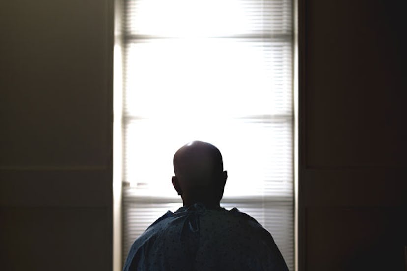 A man standing in a hospital hallway with his back turned 