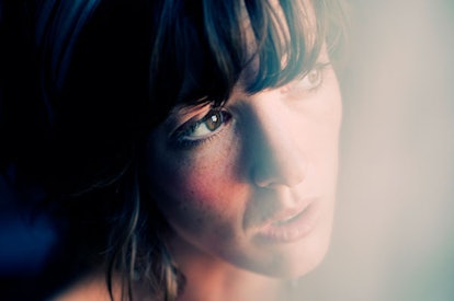 Young woman looking through window.