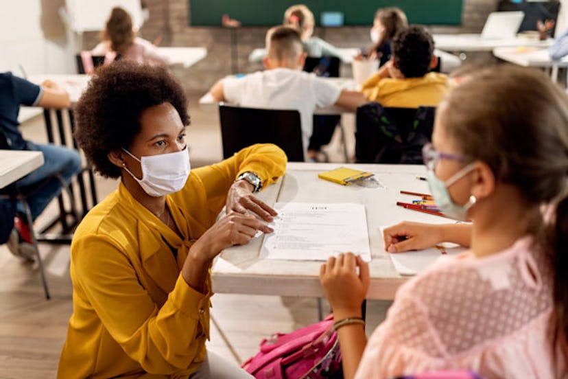 A curly-haired teacher with a mask in class during the pandemic