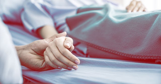 A man holding a woman's hand while she is lying in a hospital bed after having an abortion due to th...
