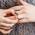 Lady with black nails taking off her wedding ring