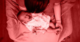 A baby crying while her mother is holding her 