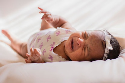 A crying baby lying in the bed 