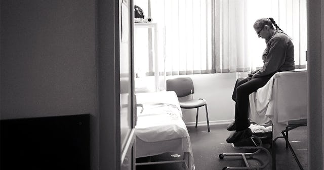 Old woman sitting in the room in hospice