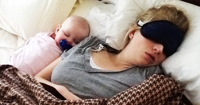 A newborn sleeping close to her mum on a bed, feeling safe