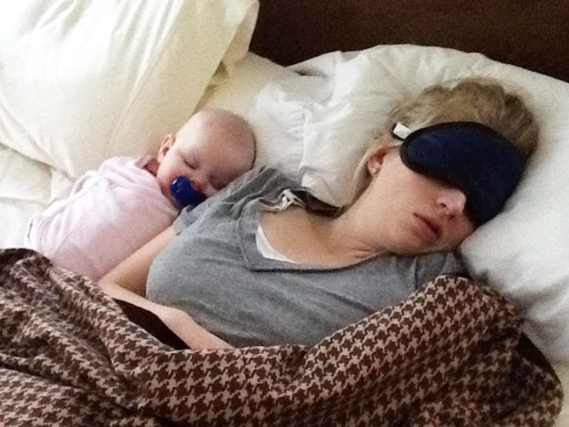 A newborn sleeping close to her mum on a bed, feeling safe.