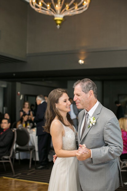 A bride in a white dress dancing with her father in a grey suit who has Alzheimer's disease