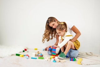A mom and a daughter playing with blocks on the floor