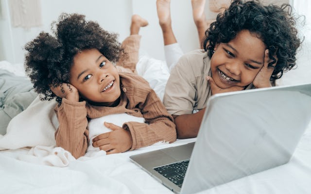 two happy children watching laptop