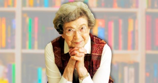 Ramona Quimby leaning on her hands  with a blurry bookshelf in the background
