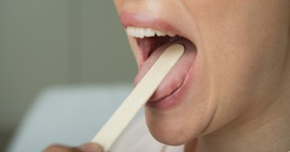 tongue feels weird, doctor checking woman's tongue with tongue depressor