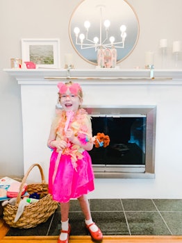 A girl wearing pink heart sunglasses over her pink eyeglasses and a pink tutu smiling in front of a ...