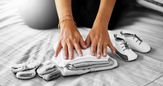 A close-up of a woman folding her dead daughter's clothes to donate them