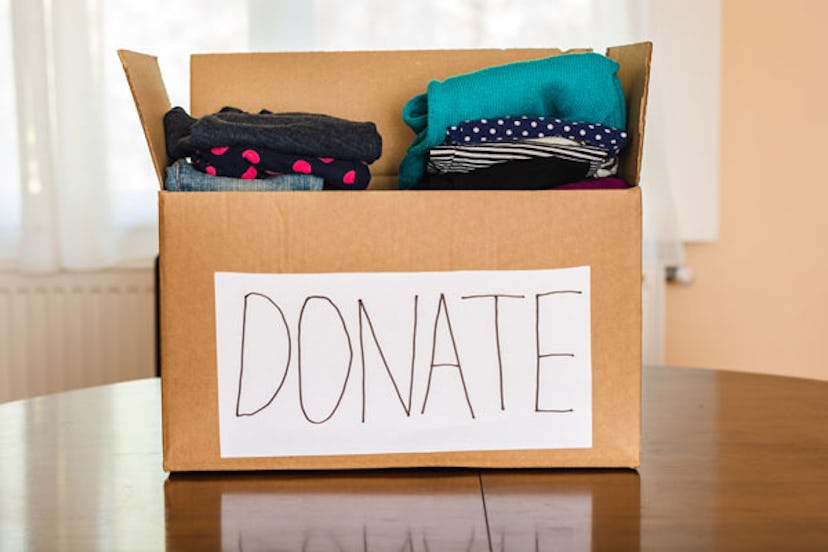 A box full of clothes with a "DONATE" poster on it