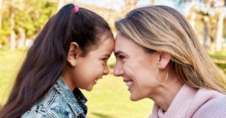 Closeup of a mother and daughter moment, smiling at each other while being very close