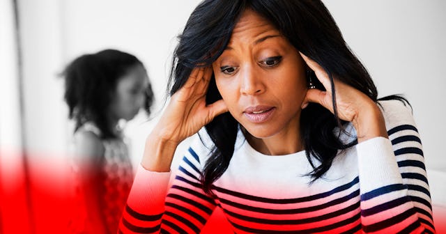 A mother holding her hands on her head and is upset while her daughter is standing in the background