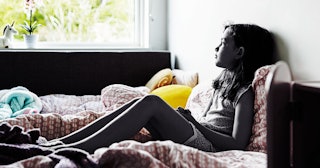 Girl sitting in her room on the bed 