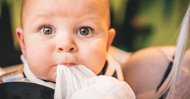 Staph infection babies, white baby looking worried and chewing on a blanket