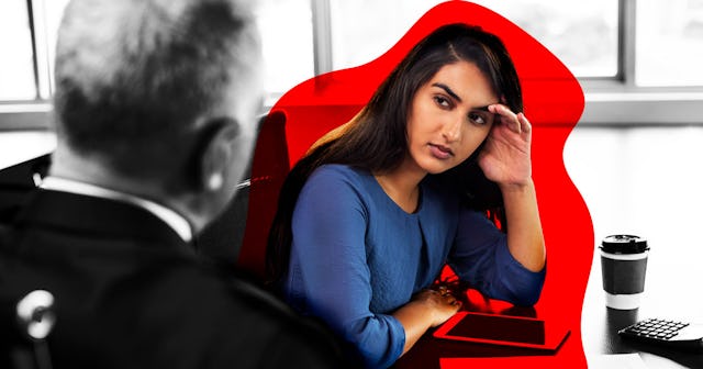 Younger woman holding her head while looking at the man who is sitting opposite her
