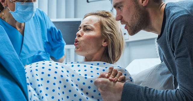 A woman giving birth to her baby on a hospital bed