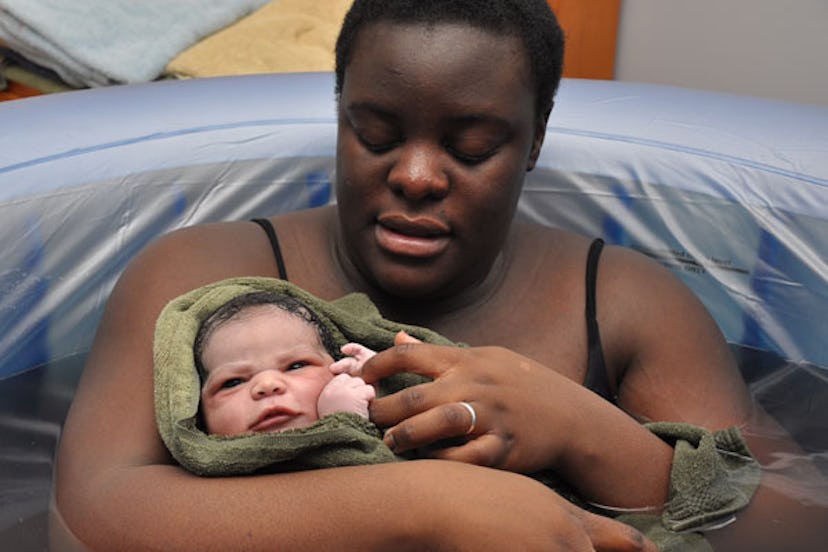Woman holding a baby wrapped in a towel