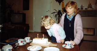 A mother blowing out birthday candles with her daughter for her second birthday