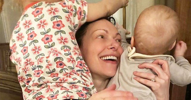 Laura Prepon who makes 'Trojan Foods' that have veggies in them smiling and posing her two little ki...