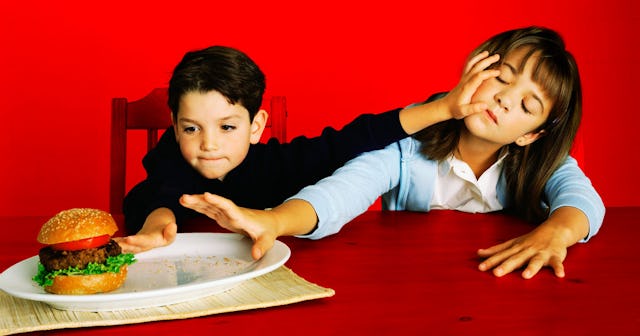 Brother taking away hamburger from his sister