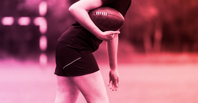 A fotball mom holding a football at a stadium with a pink color filter