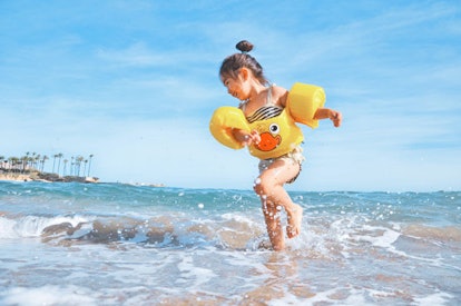 A small girl playing in the sea at the beach