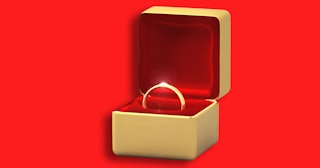 Golden wedding ring in a golden ring box with red velvet padding 