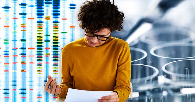A woman in an orange long-sleeved shirt wearing black glasses reading the results of a genetic test