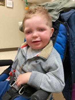 Five-year-old Cameron smiling in his wheelchair