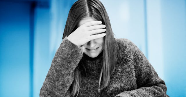 A depressed woman covering her face with hands while crying