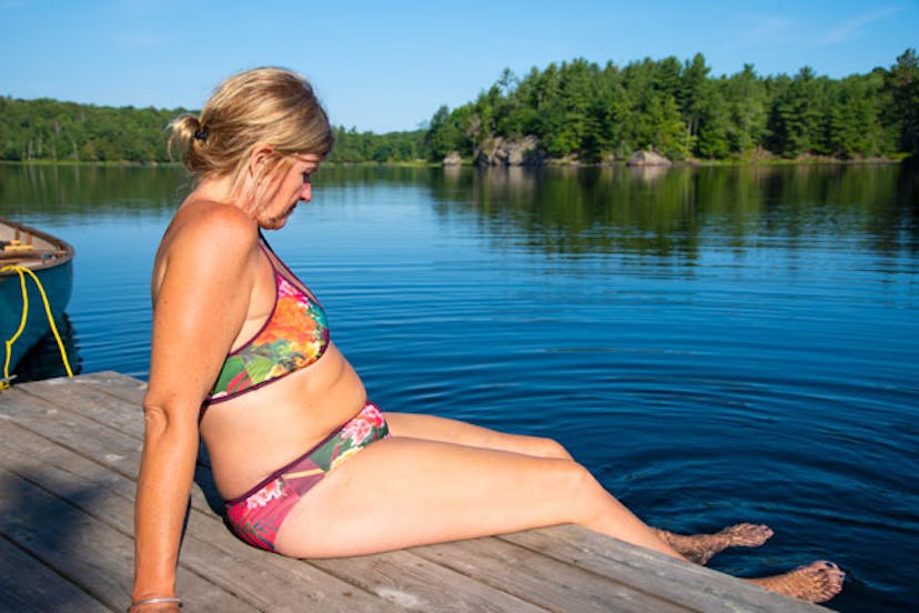 Woman in a bikini sitting on a pier